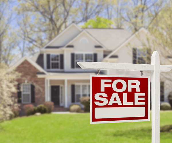 "House for sale sign in front of a welcoming suburban home, indicating availability in the real estate market."